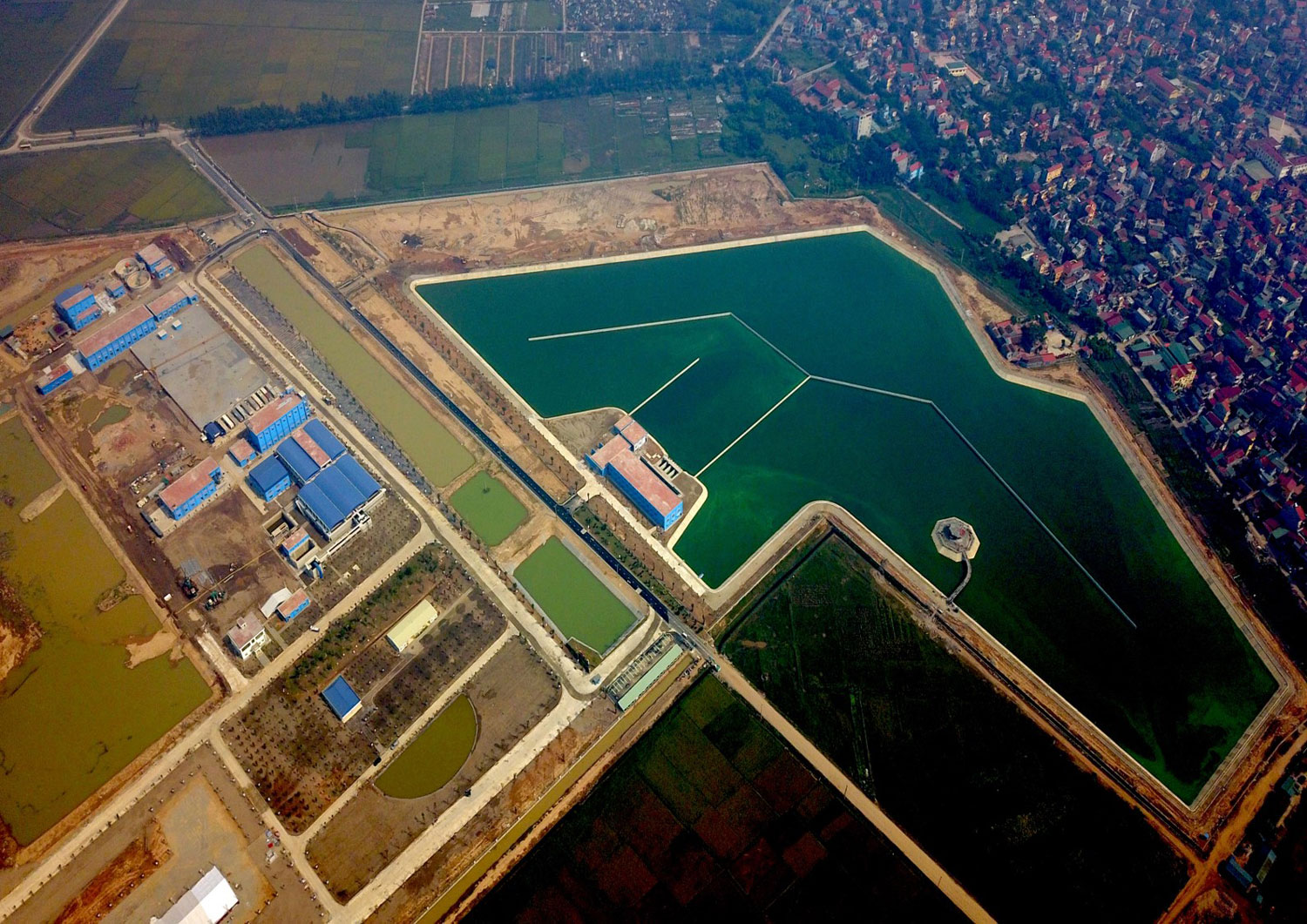 Luftaufnahme des vietnamesischen Wasserwerks Soung Duong mit der angrenzenden Metropole Hanoi