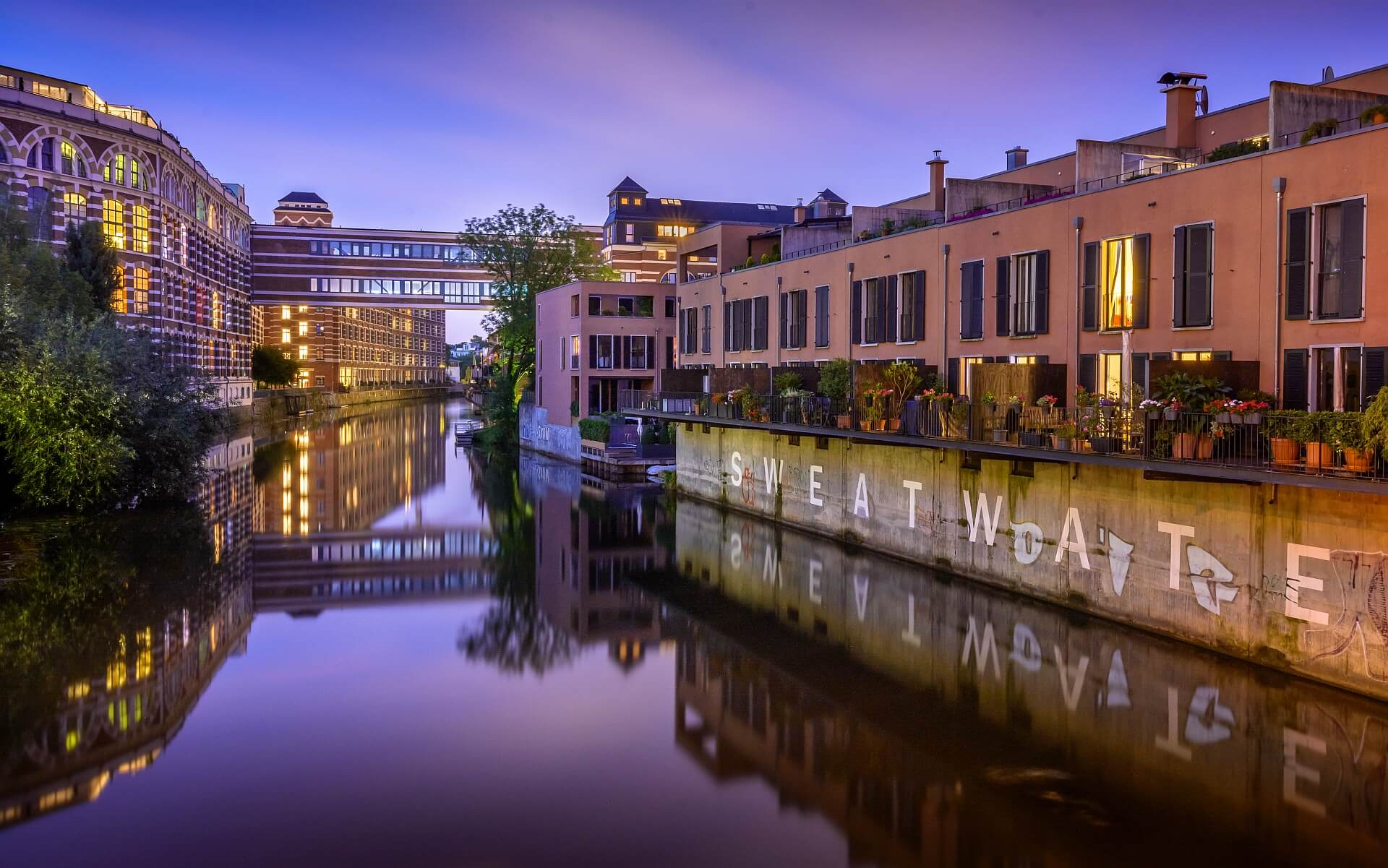 Ansicht des Karl-Heine-Kanals in Leipzig in abendlicher Stimmung mit sich im Wasser spiegelnder Industriearchitektur des 19. Jahrhunderts